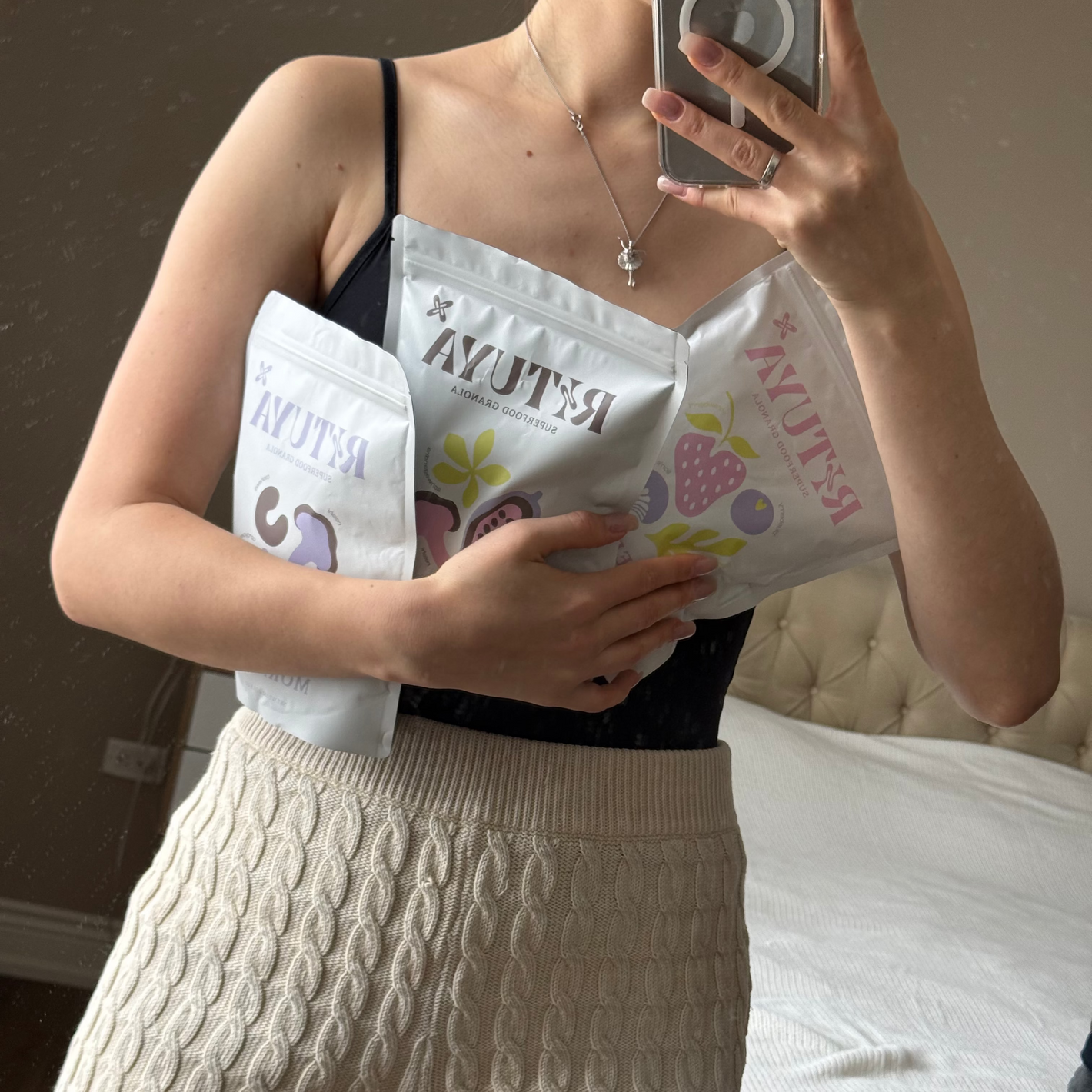 Person holding three packages labeled RITUYA in a room.